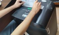 Funcionario pasando las hojas por la maquina para su eliminación