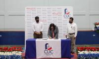 Ministra firma un documento. De testigo el Presidente de la República. 